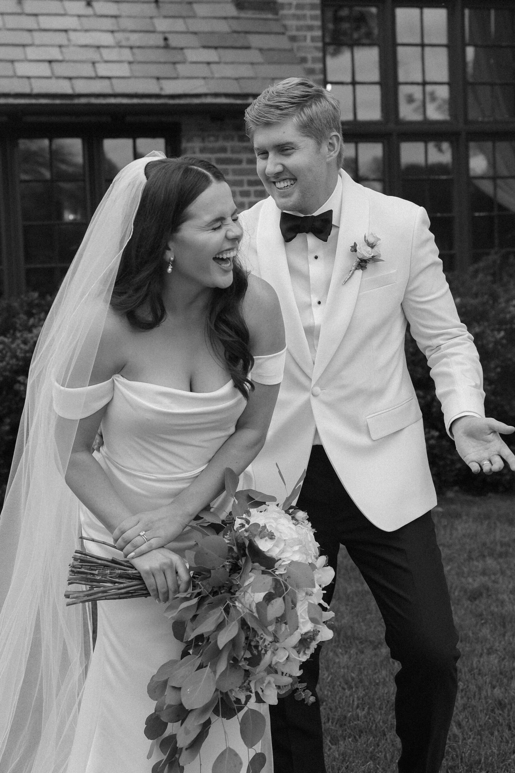 Bride and groom laughing in black and white photo