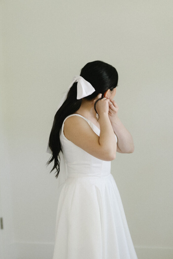 bride putting on earrings 