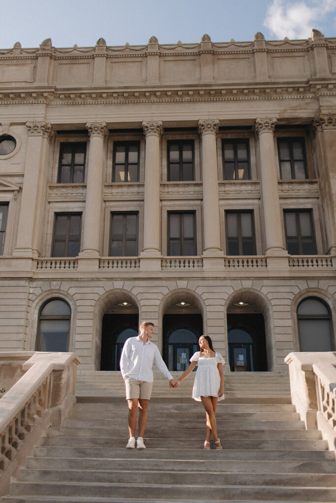 Couple posing for Omaha, Nebraska Engagement Pictures outside of Central High School Downtown 