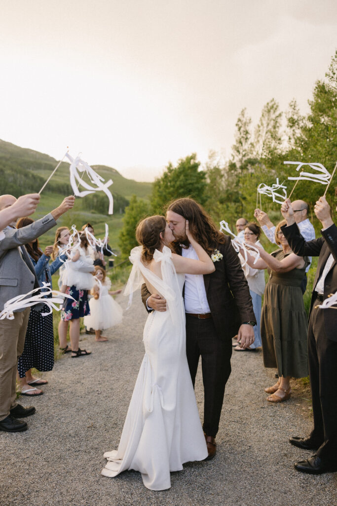 an adorable send off for the bride and groom with ribbons and the mountains in the background