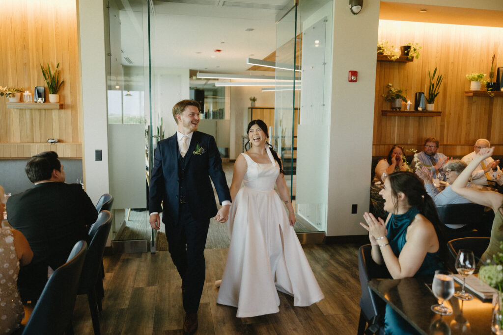 Bride and groom enter their small wedding reception at a lincoln nebraska restaurant 