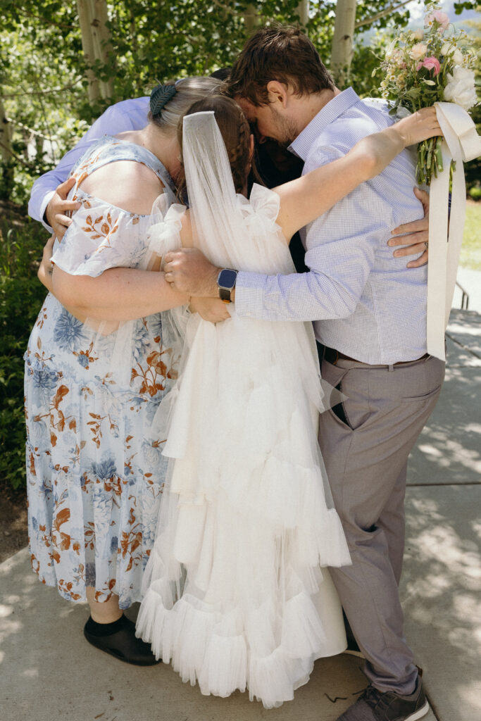 bride gets ready and hugs family before a small wedding in the mountains