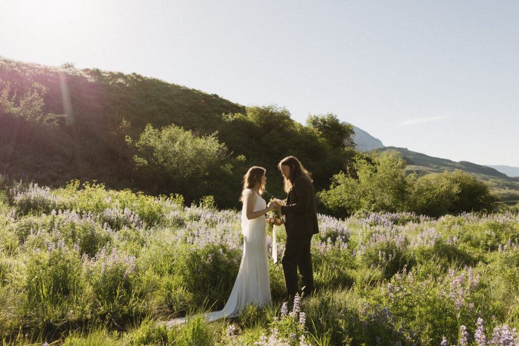 Bride and groom exchange private vows in a field of wildflowers