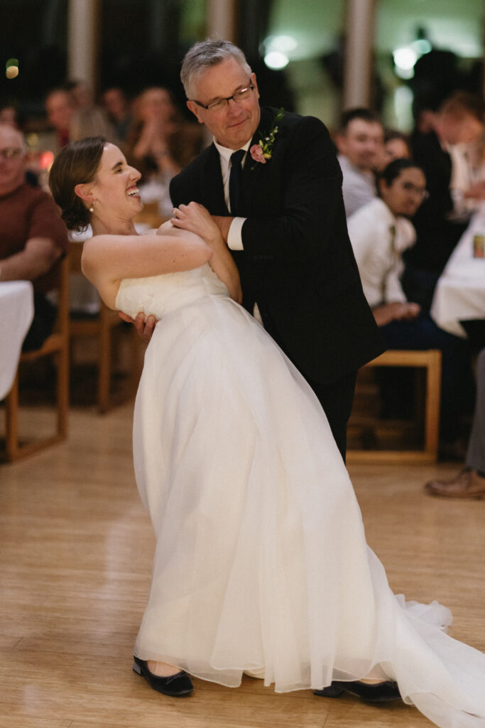 bride and her father laugh on the dance floor 