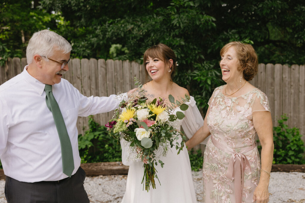documentary wedding photographer captures candid moment of bride and her parents 