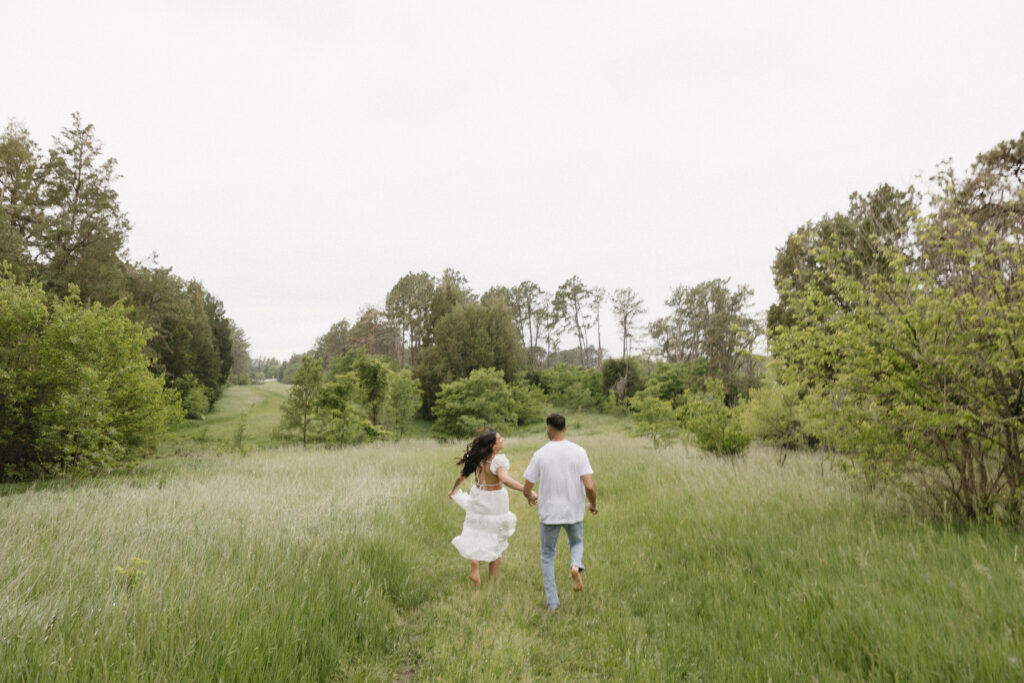 couple runs in grass barefoot 
