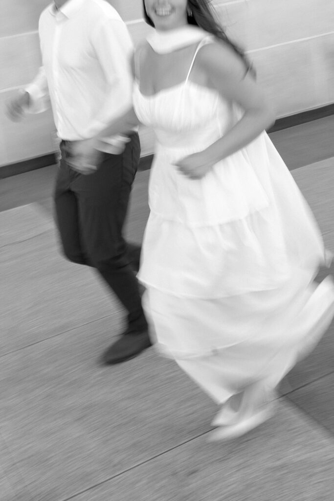 in motion engagement photo of couple running 