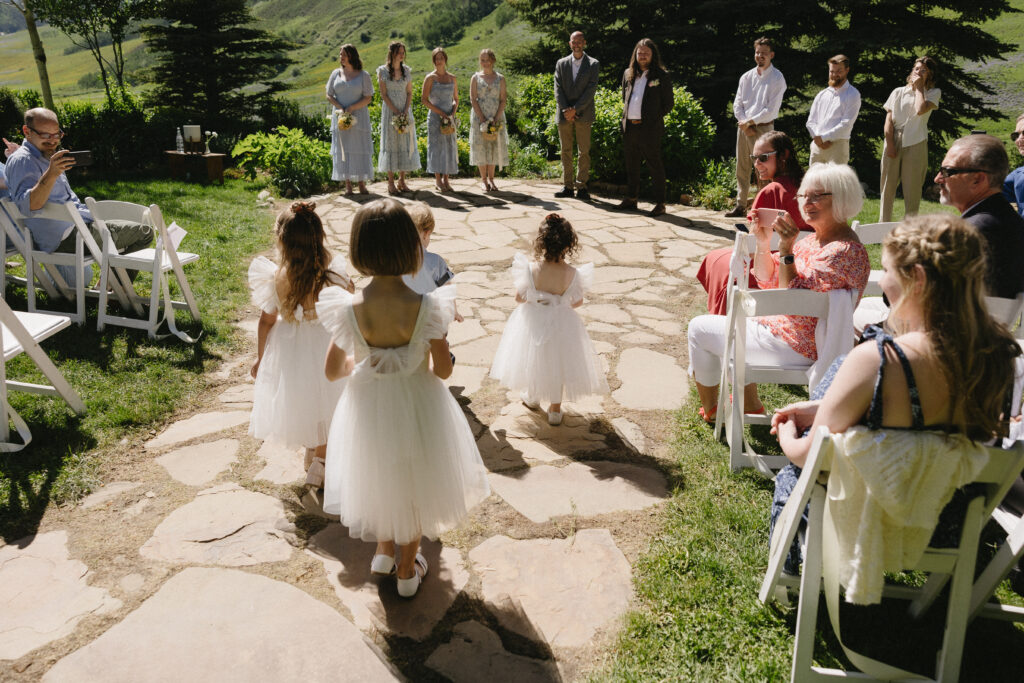 flower children walk down the aisle at outdoor wedding in colorado