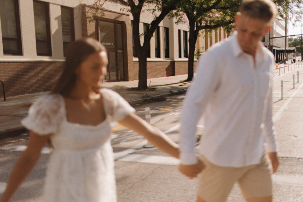walking hand in hand across the street downtown 