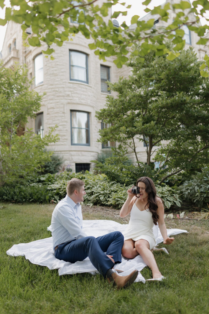 Emmy and Kipper snap photos of each other at their engagement session at the Joslyn Castle