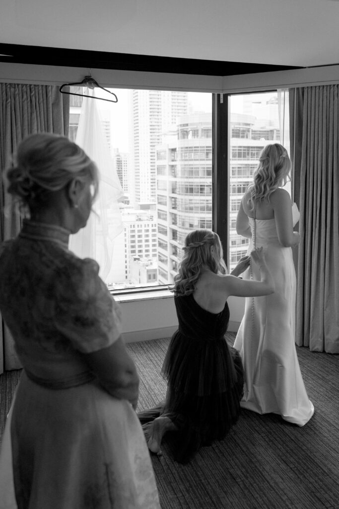 bride's sister helps her into her dress