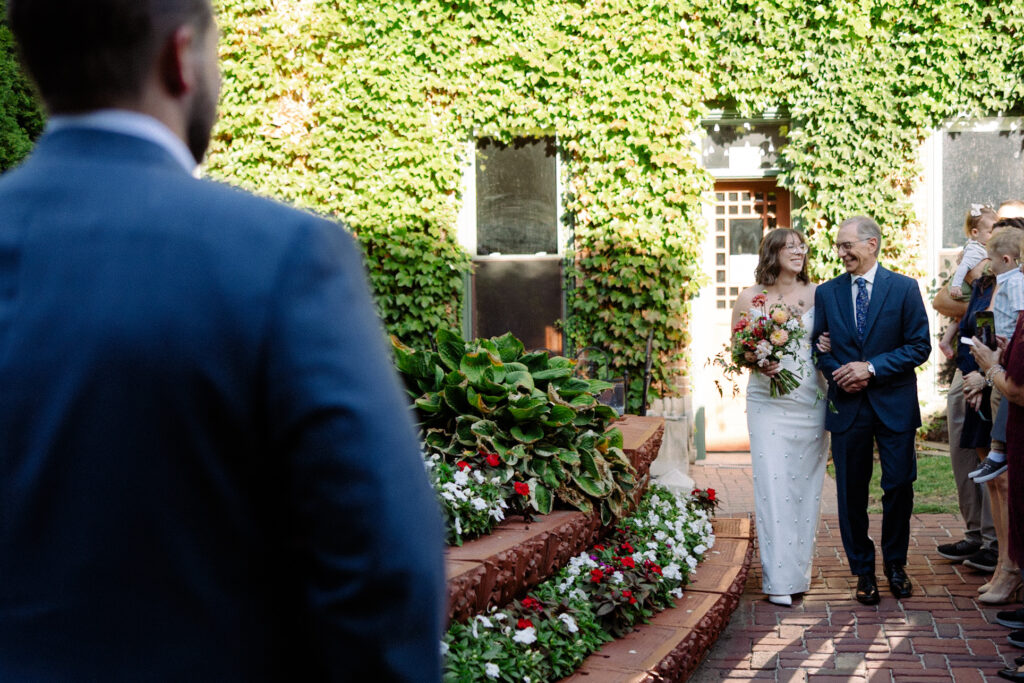 bride walks down the aisle with her father 