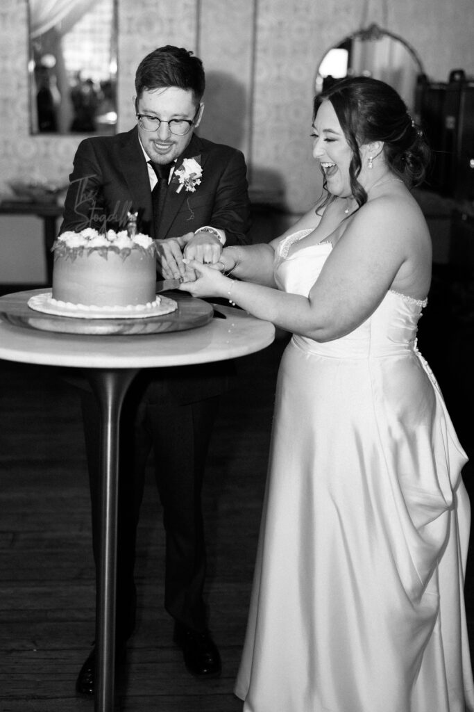 bride and groom cut their cake at their vintage ballroom wedding 